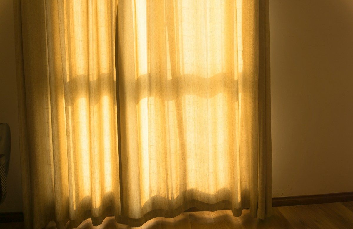 Soleil filtrant à travers des rideaux clairs
