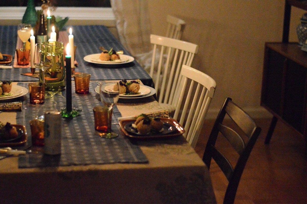 Table dressée le soir, éclairée par des bougies